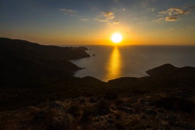 Gün batımında kayalık deniz kıyısı