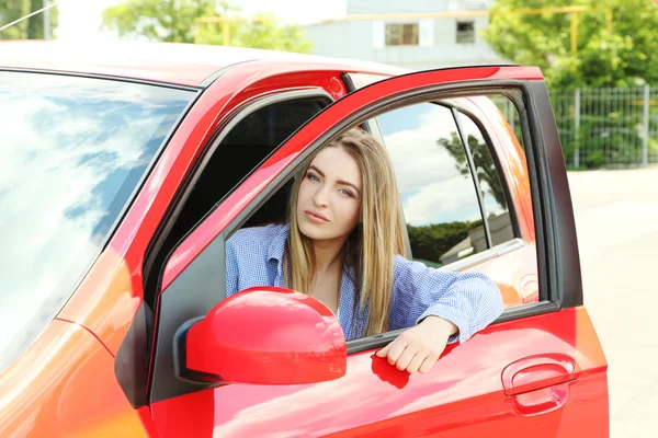 Menina sentada no carro vermelho — Fotografia de Stock