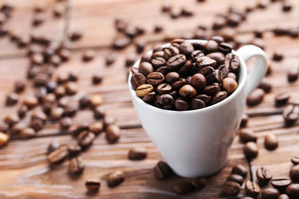 Жареные кофейные зерна в чашке — стоковое фото