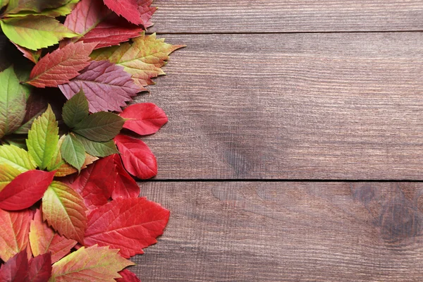Autumn listowie na brązowy stół — Zdjęcie stockowe