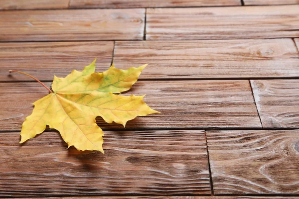 Foglia d'autunno sul tavolo marrone — Foto Stock