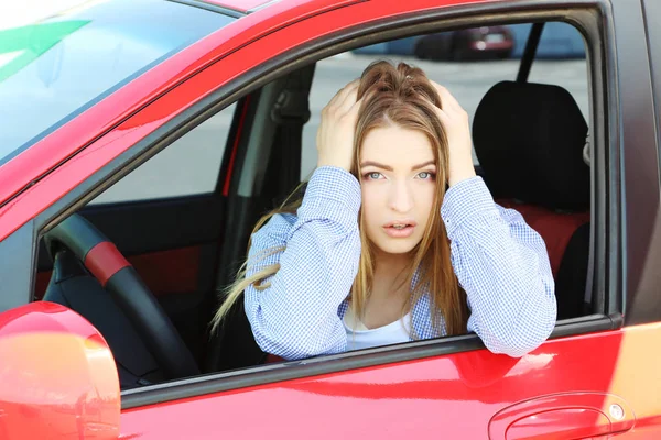 Giovane ragazza seduta in auto rossa — Foto Stock