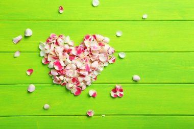 Gül yaprakları üzerinde ahşap masa