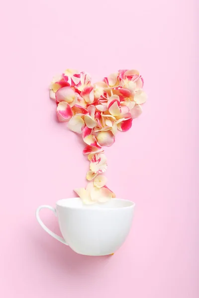 Pétalos de rosa y copa blanca — Foto de Stock