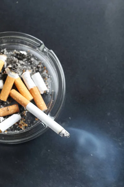 Colillas de cigarrillo con ceniza en cenicero — Foto de Stock
