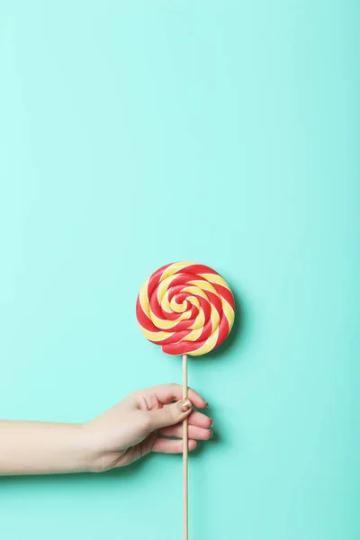 Female hand holding lollipop — Stock Photo, Image