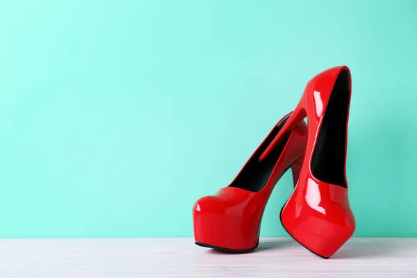 Kobiet czerwony obcasie buty na drewnianym stole — Zdjęcie stockowe