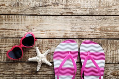 Güneş gözlüğü ve deniz yıldızı ile flip flop 