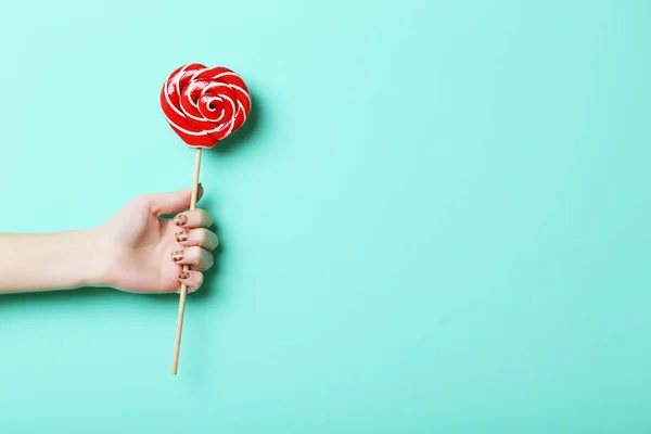 Female hand holding lollipop — Stock Photo, Image