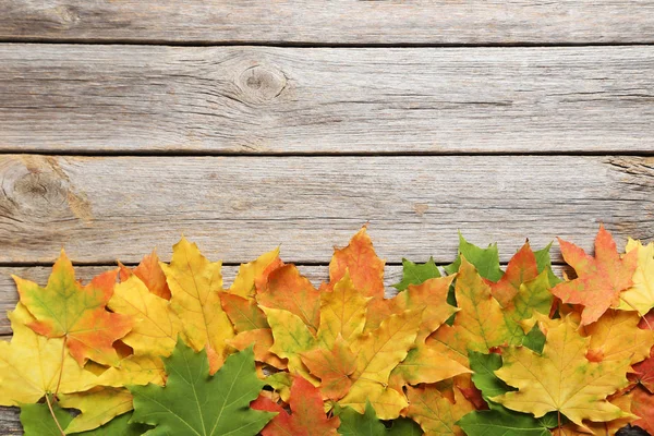 Hojas de otoño sobre mesa de madera — Foto de Stock