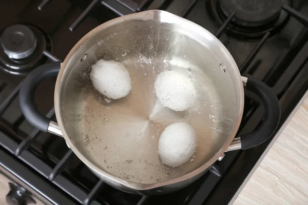 Huevos blancos en agua hirviendo — Foto de Stock