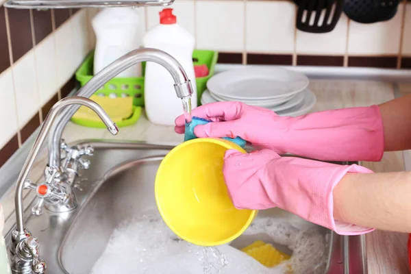 Kvinnliga händer med svamp tvätta skålen — Stockfoto
