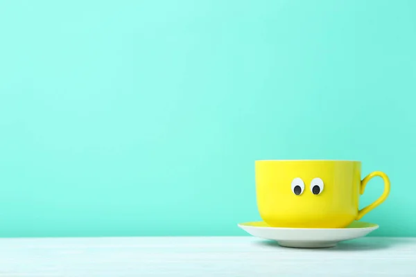 Taza amarilla con ojos pegajosos — Foto de Stock