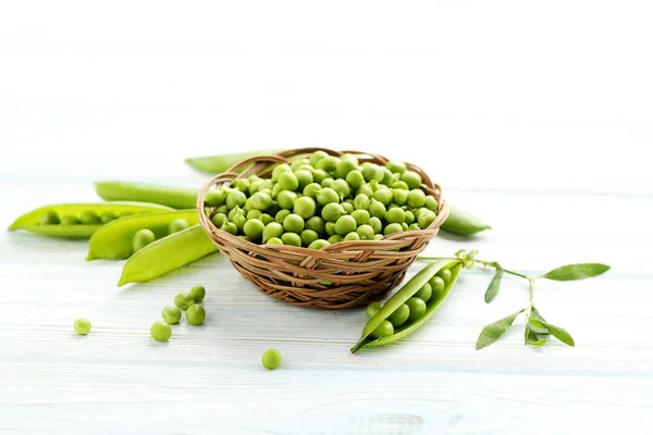 Ervilhas verdes na mesa de madeira — Fotografia de Stock