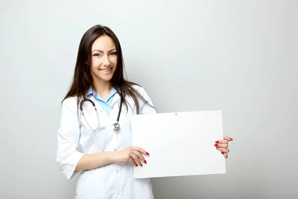 Retrato de jovem médico com folha sobre papel em branco em um — Fotografia de Stock