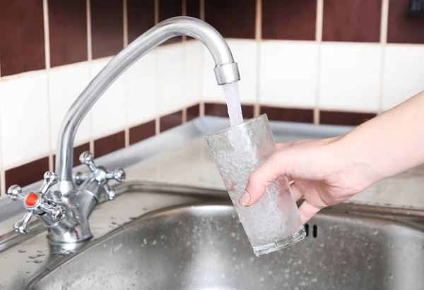 Glass filled with water from faucet — Stock Photo, Image