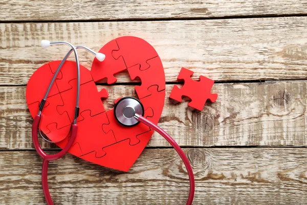 Красное сердце-головоломка со стетоскопом — стоковое фото