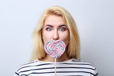 Lolipop gri arka plan üzerinde olan güzel kadın