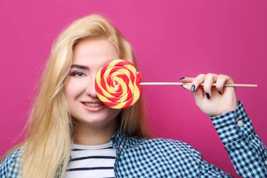 pembe bir arka plan üzerinde lolipop ile genç güzel kadın