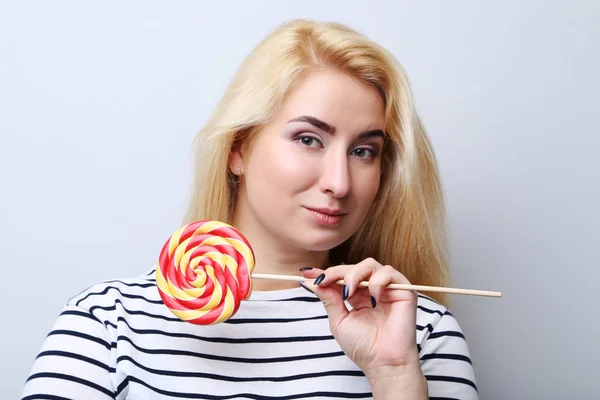 Ung vacker kvinna med lollipop på grå bakgrund — Stockfoto