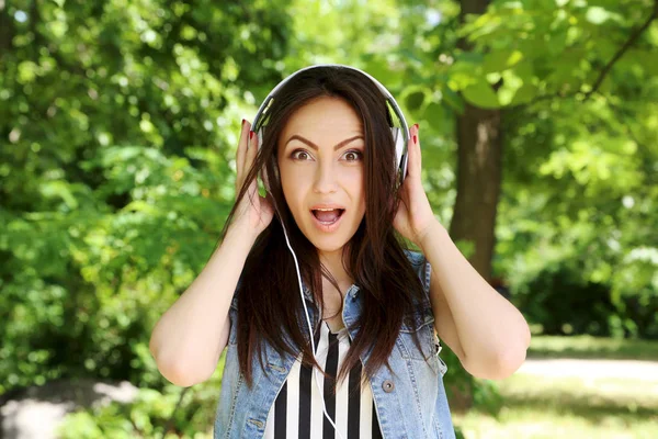 Mooie jongedame luisteren muziek met koptelefoon buitenshuis — Stockfoto