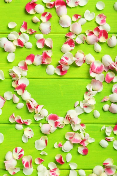 Pétalos de rosa sobre mesa de madera verde — Foto de Stock