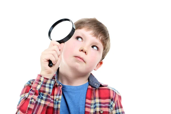 Young boy with magnifying glass on a white background — Stock Photo, Image