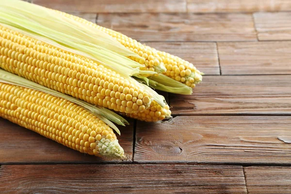 Sweet corncobs on wooden table — Stock Photo, Image