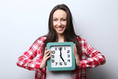 Elinde saat tutan genç bir kadın.