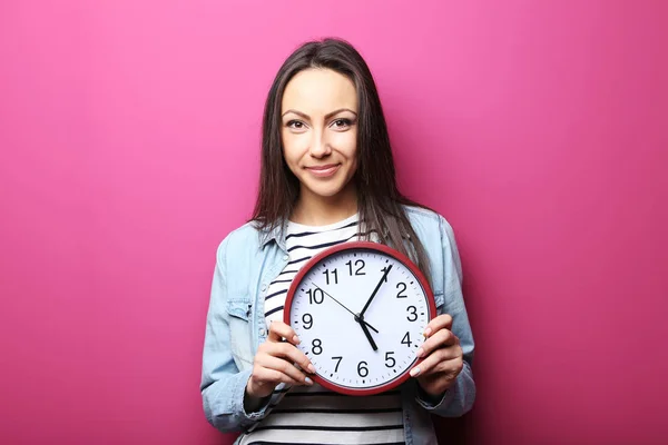 Jonge vrouw met een klok — Stockfoto