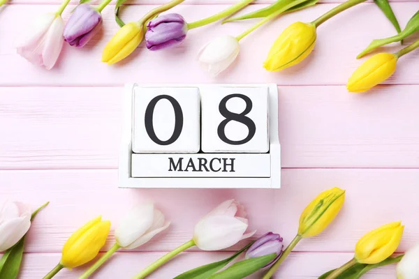 Bouquet of tulips with cube calendar on table — Stock Photo, Image