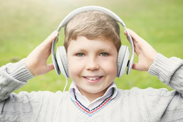 Jongen met koptelefoon in park — Stockfoto