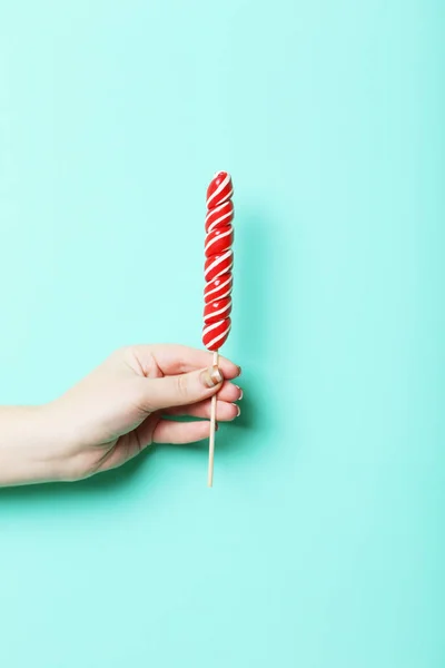 Kvinnlig hand innehav lollipop — Stockfoto
