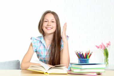 Masada oturan ve kitap okuma genç kız 