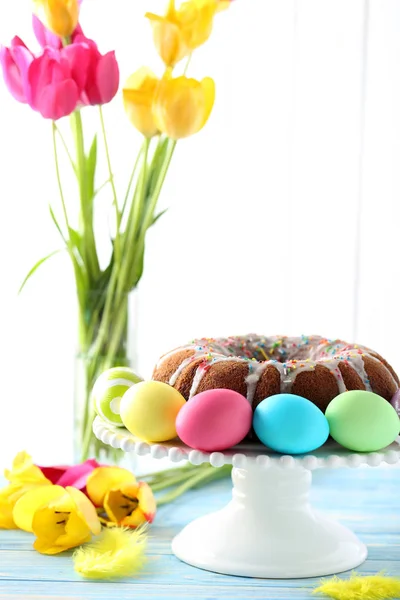 Easter cake and eggs with bouquet of tulips