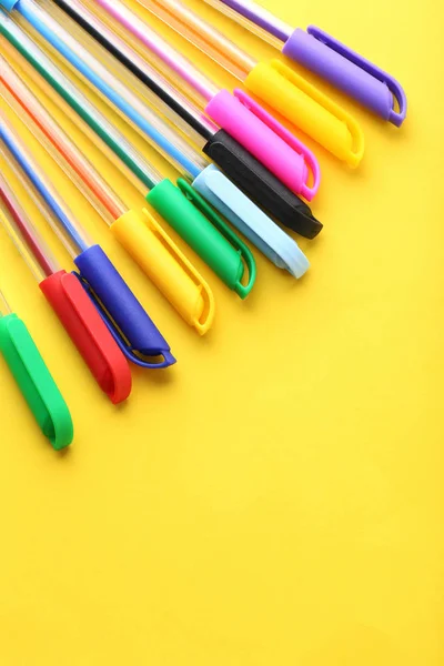 Kolorowe długopisy na żółtym tle — Zdjęcie stockowe
