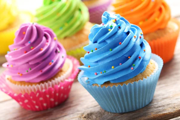 Sabrosos cupcakes sobre una mesa de madera gris — Foto de Stock