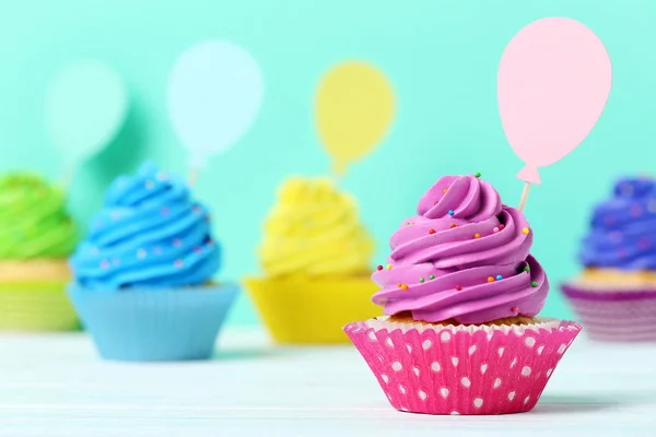 Sabrosos cupcakes sobre un fondo verde — Foto de Stock