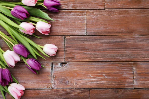 Tulips on a brown wooden table — Stock Photo, Image