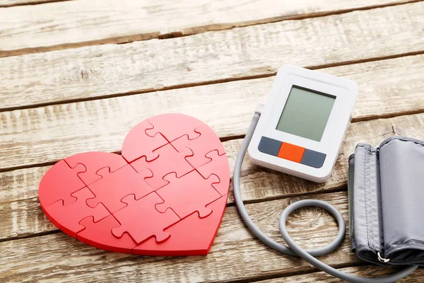 Tonometer listrik putih dan jantung merah — Stok Foto