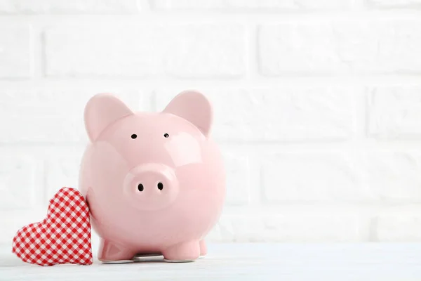 Pink piggy bank with red heart