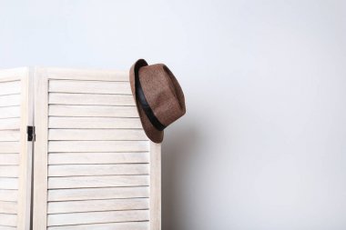 Ahşap katlanır ekran üzerinde asılı şapka