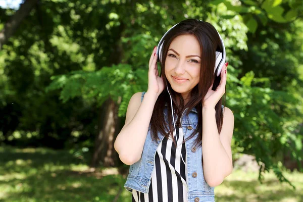 Mooie jongedame luisteren muziek met koptelefoon buitenshuis — Stockfoto