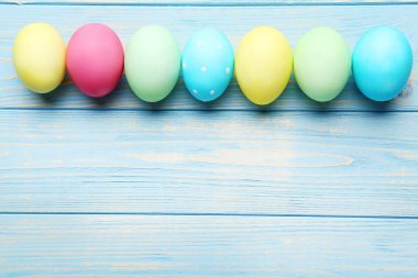 Mavi ahşap bir masada paskalya yumurtaları