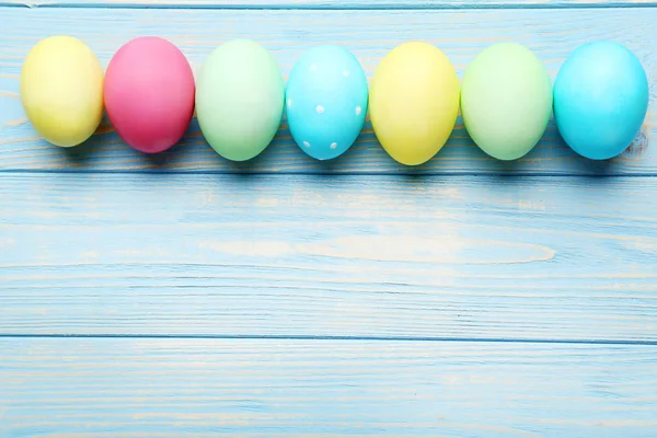 Mavi ahşap bir masada paskalya yumurtaları