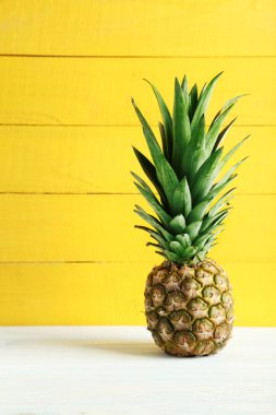 Beyaz ahşap bir masa üzerinde olgunlaşmış ananas