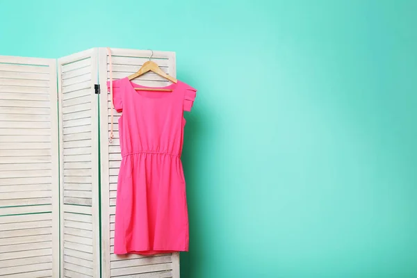 Pinkfarbenes Kleid hängt auf Klappbildschirm — Stockfoto
