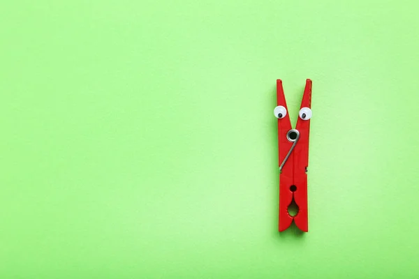 Plastic clothespin on a green background
