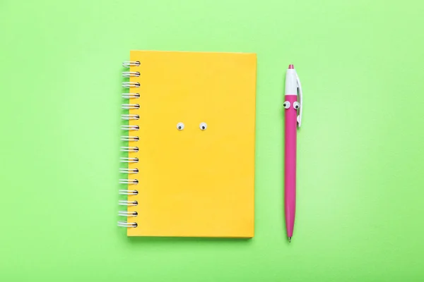 Anteckningsbok och penna med googly ögon — Stockfoto