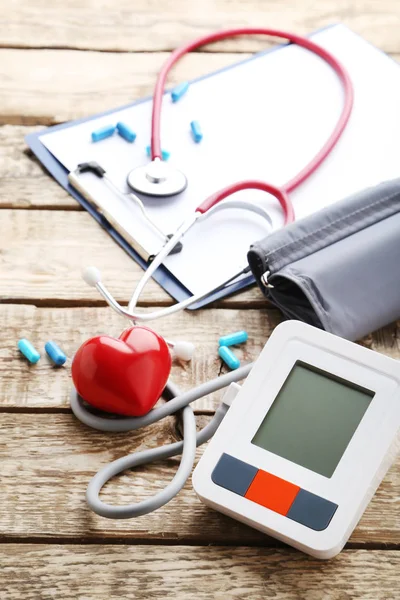 Tonometer listrik dengan stetoskop dan hati merah — Stok Foto